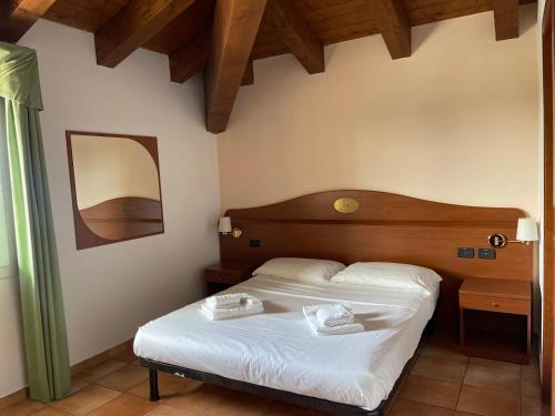a bedroom with a bed with two towels on it at Hotel Conte Luna in Bologna