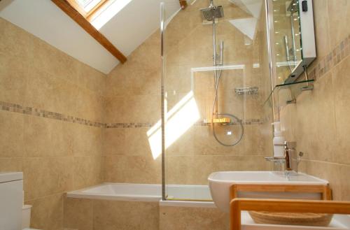 Un baño con ducha, bañera y lavabo. en The Dovecote Llechryd, en Llechryd