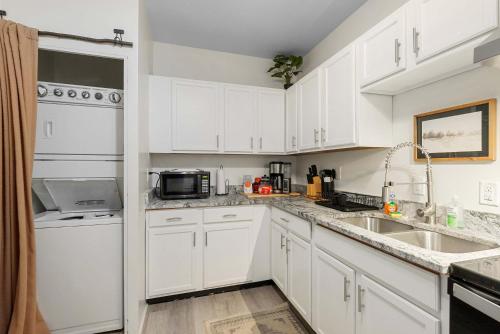 a white kitchen with a sink and a microwave at The Luxe Pearl Residences 870-5 in Columbus