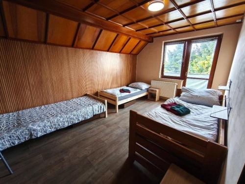 a bedroom with two beds and a window in it at Apartmány ŠTĚSTÍ in Bechlín