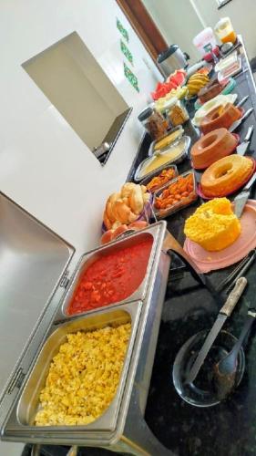 um buffet cheio de diferentes tipos de alimentos em Hotel Ideal em Jequié