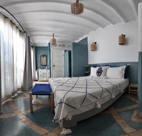 a bedroom with a large bed and blue walls at Riad Birdy, Charmant et privatif, Piscine, Rooftop, 6 suites, 2 salons, Wifi in Marrakesh