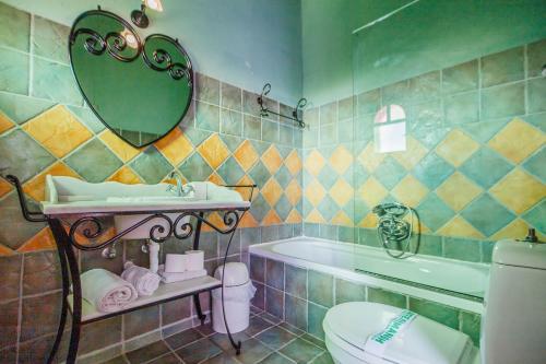 une salle de bains avec lavabo, baignoire et toilettes dans l'établissement Villa Carolina, à Áyios Dhimítrios