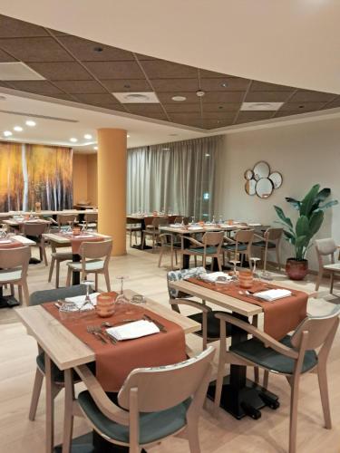 a restaurant with tables and chairs in a room at Les Belles Lettres in Herblay
