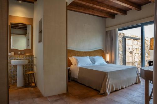 a bedroom with a large bed and a bathroom at Resort Fontes Episcopi in Aragona