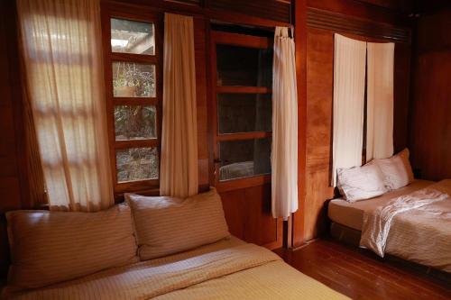 Un dormitorio con dos camas y dos ventanas. en Cottown homestay, en Khu Chi Lăng