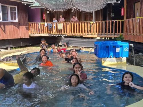 un grupo de personas nadando en una piscina en Tambatuon Homestead, en Kota Belud
