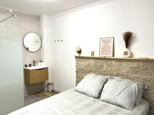a bedroom with a bed and a stone wall at Appartement de Charme au cœur de Montendre in Montendre
