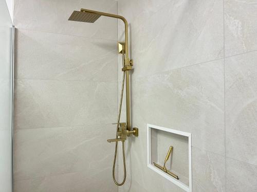 a shower with a shower head in a bathroom at Appartement de Charme au cœur de Montendre in Montendre