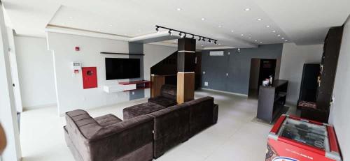 ein Wohnzimmer mit Sofa und Fernseher in der Unterkunft Hotel Ideal 5 in Araguaína