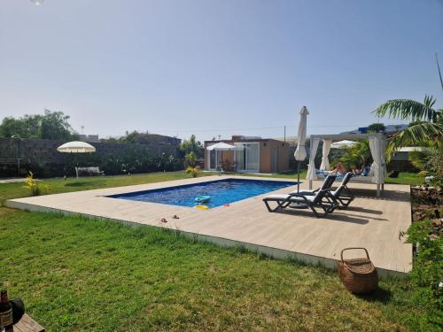 una piscina con dos sillas y una sombrilla en Casa Deco, en San Borondón