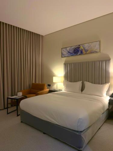 a hotel room with a large bed and a chair at فندق ايون - حي الملك عبد العزيز in Riyadh