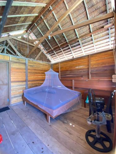 a bed in a room in a wooden house at Marlina Homestay in Fam