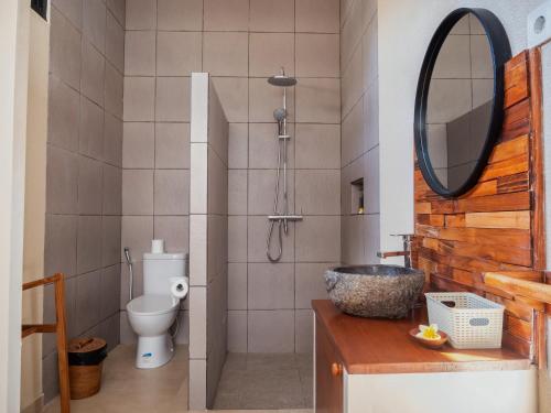 a bathroom with a toilet and a mirror at LM Home Mendira in Candidasa