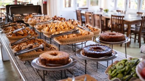 a table with many different types of cakes and pastries at Ville Real Hotel in Santo Antônio do Leite