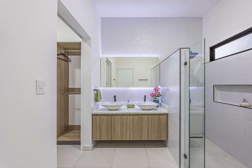 une salle de bain avec deux lavabos et un miroir dans l'établissement Uvita-new Luxury-sleeps 6-private Pool-huge Patio, à Uvita