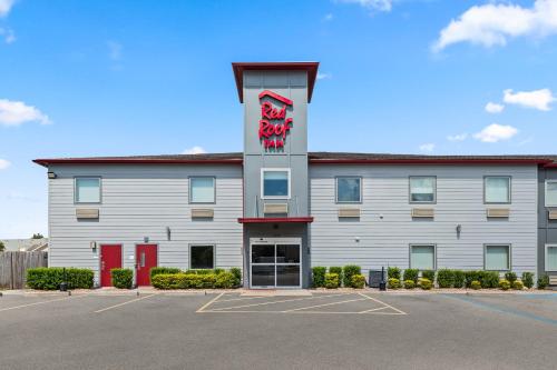a hotel with a sign on the side of a building at Red Roof Inn Baton Rouge in Baton Rouge