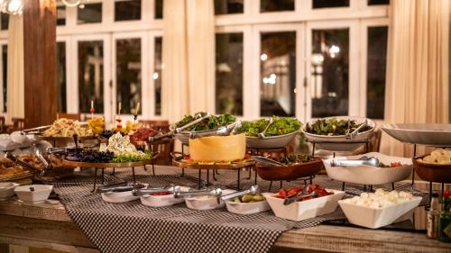 a buffet with many plates of food on a table at Ville Real Hotel in Santo Antônio do Leite