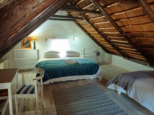 a bedroom with a bed and a window in a attic at The Coach House Bredasdorp in Bredasdorp
