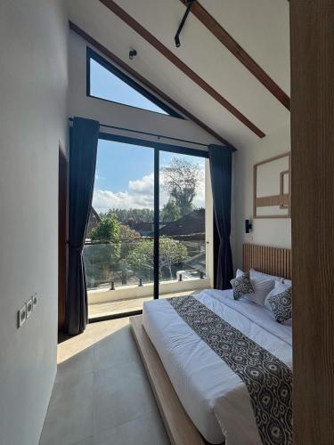 a bedroom with a bed and a large window at LM Home 2 Mendira in Candidasa