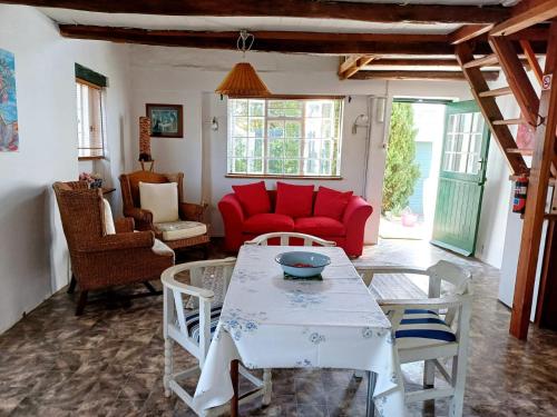 a living room with a red couch and a table at The Coach House Bredasdorp in Bredasdorp