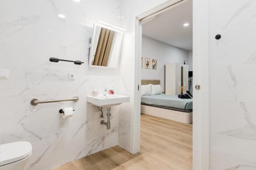 バレンシアにあるNew Studio - La puerta de olivoのバスルーム(洗面台、トイレ付)、ベッド1台が備わります。