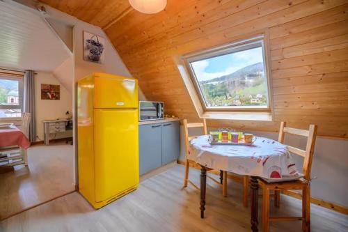 a kitchen with a table and a yellow refrigerator at Logis en montagne chez Juju in Fréland
