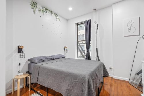 a white bedroom with a bed and a window at Lavish Downtown Manhattan Oasis in Union Square in New York