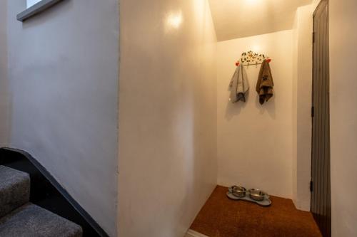 un pasillo con una escalera con zapatos en la pared en Old Stables Loft, en Kendal