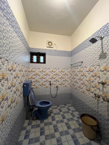 Un baño con inodoro azul y ducha. en villa mud apples, en Varkala