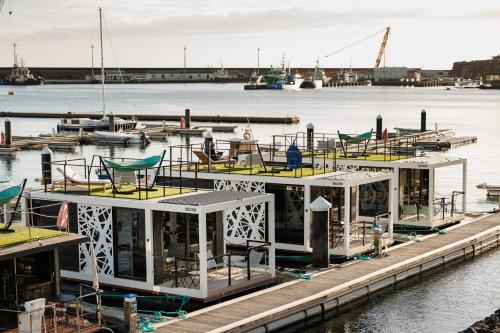 a boat is docked at a dock in the water at The Homeboat Company Ponta Delgada-Açores in Ponta Delgada