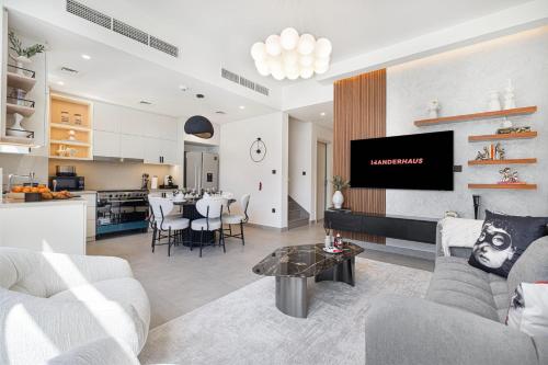 a living room with a tv and a kitchen at Upscale 4BR Villa, Bali Pool, Resort Escape in Dubai