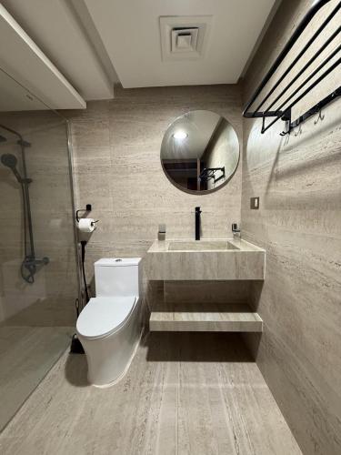 a bathroom with a toilet and a sink and a mirror at The Vendome view luxury apartment in Lusail