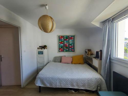 een kleine slaapkamer met een bed en een raam bij Bel appartement centre Le Palais in Le Palais