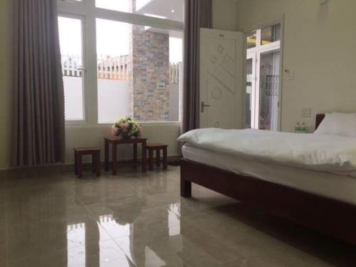 um quarto com uma cama e uma grande janela em Phuong Vy 2 em Da Lat