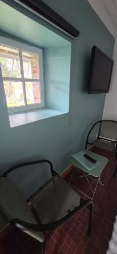 a room with a chair and a table and a window at Chambre Étape Isabielle in Saint-Vaury