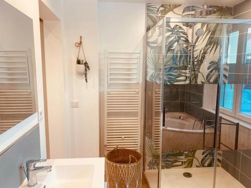 a bathroom with a sink and a shower with a tub at La Parenthèse Marine in Étaples