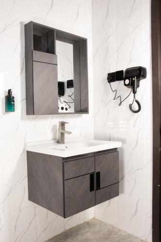 a bathroom with a sink and a mirror at Avian Court Hotel in Naivasha