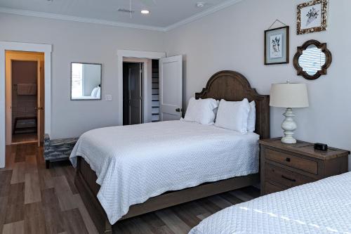 a white bedroom with two beds and a mirror at Bay to Breakers in Fort Morgan