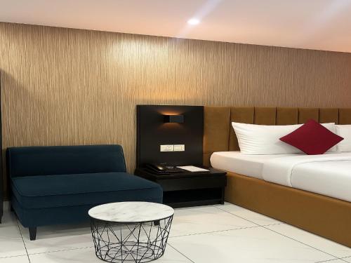 a bedroom with a bed and a blue chair at NO 95 SUITES VI in Lagos