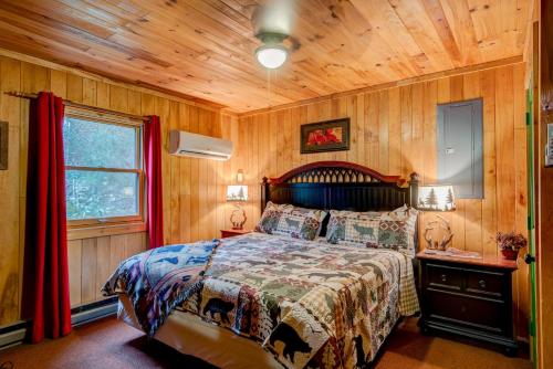 a bedroom with a bed and a wooden wall at Bridgepoint Cabin in Banner Elk