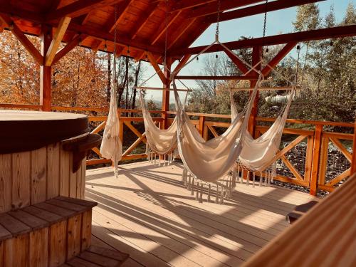 a porch with hammocks on a wooden deck at Domki Na Wypasie Jacuzzi & Sauna in Białka Tatrzanska