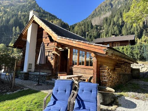 a log cabin with two blue chairs in front of it at Romantikhütte in Flattach