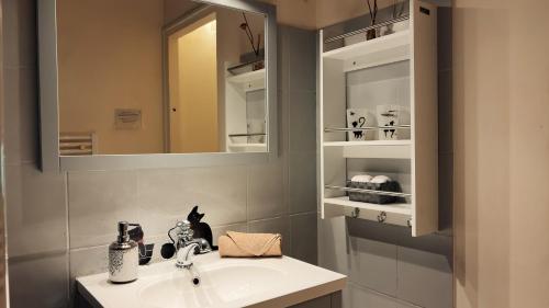 a bathroom with a sink and a mirror at Logis des Lauriers Roses in Marennes