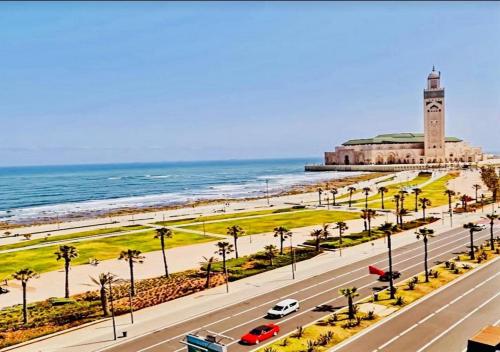 a road with a clock tower on the beach at Morocco House in Casablanca