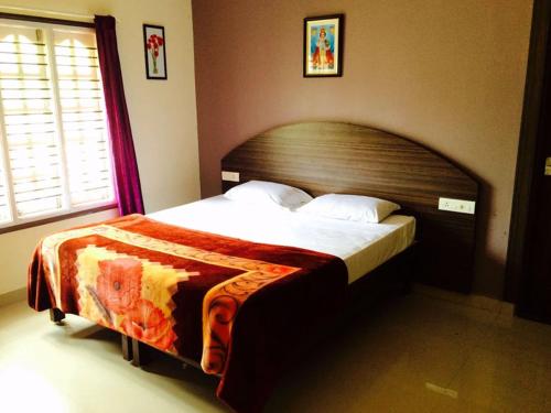 a bedroom with a large bed with a wooden headboard at Green Leaf Nature HomeStay in Santaveri