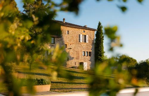 a large brick building with trees in the foreground at La bastide de Meilhouret in Larroque