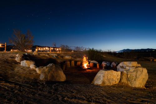 a fire pit with rocks in a field at night at Desert Haven, Pickleball, Stargazing, Spa & Views in Joshua Tree