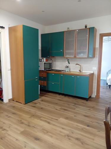 Il comprend une cuisine avec des placards verts et du parquet. dans l'établissement Ai 4 gatti, à Mascalucia