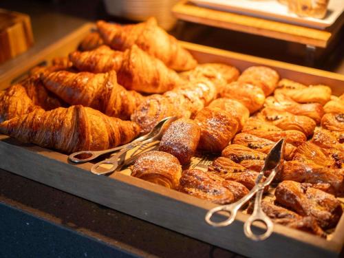 Una bandeja de pasteles y croissants en una panadería. en Pullman Adelaide, en Adelaida